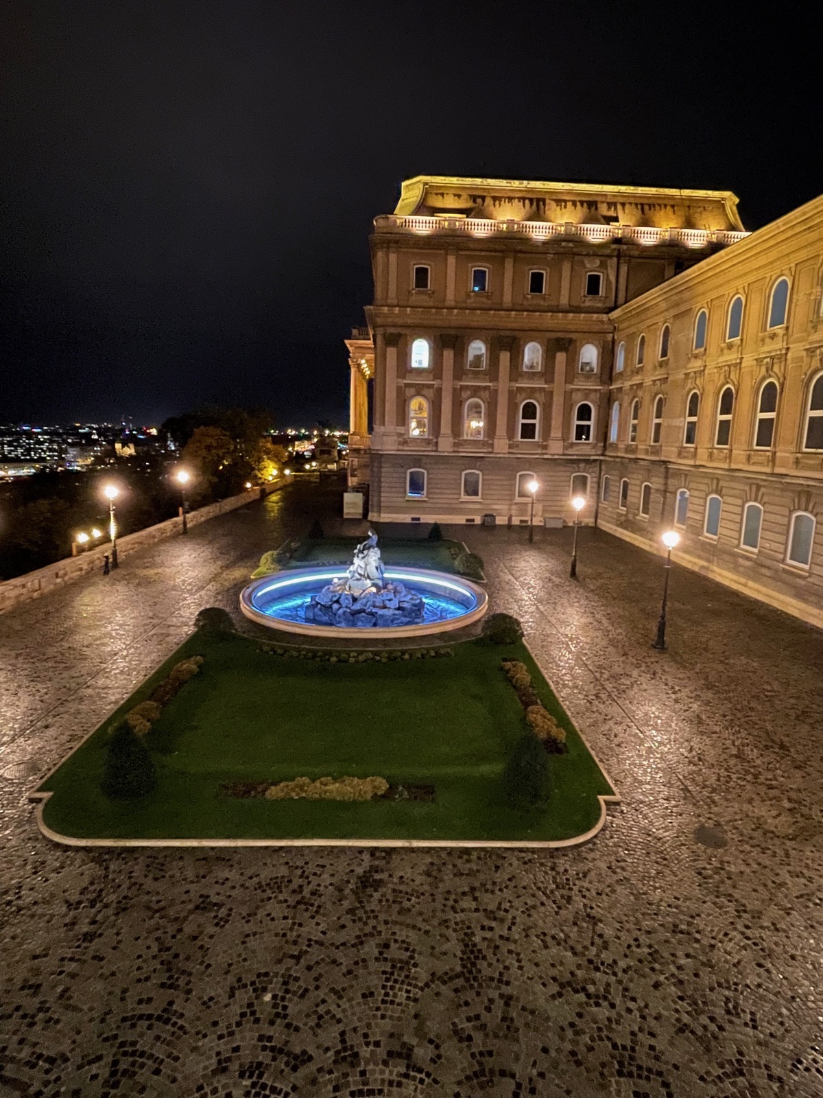 Buda Castle fountain and facade at night
