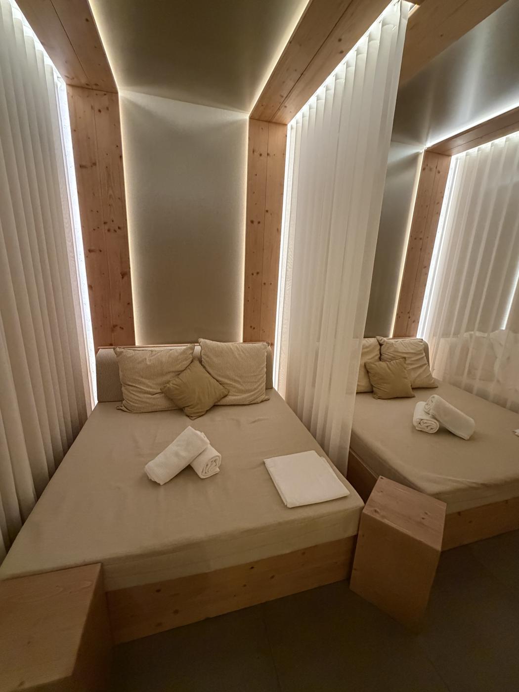 Lounge beds framed by white curtains in the Sunrose 7 spa