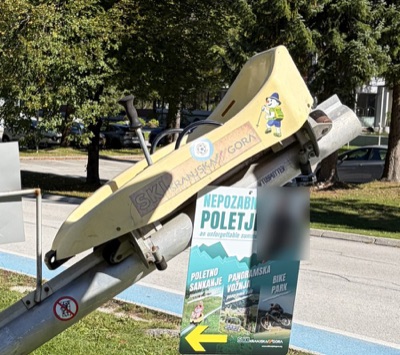 A yellow mountain coaster sled on display in Kranjska Gora