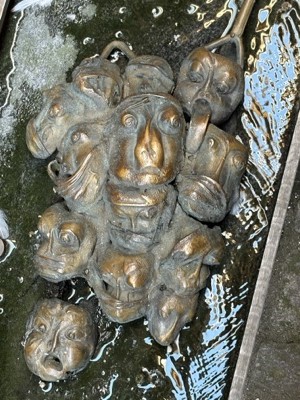 Bronze faces set into the pavement of Locksmith Alley, Ljubljana